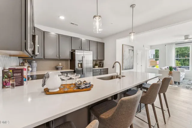 a kitchen with a dining table chairs and refrigerator