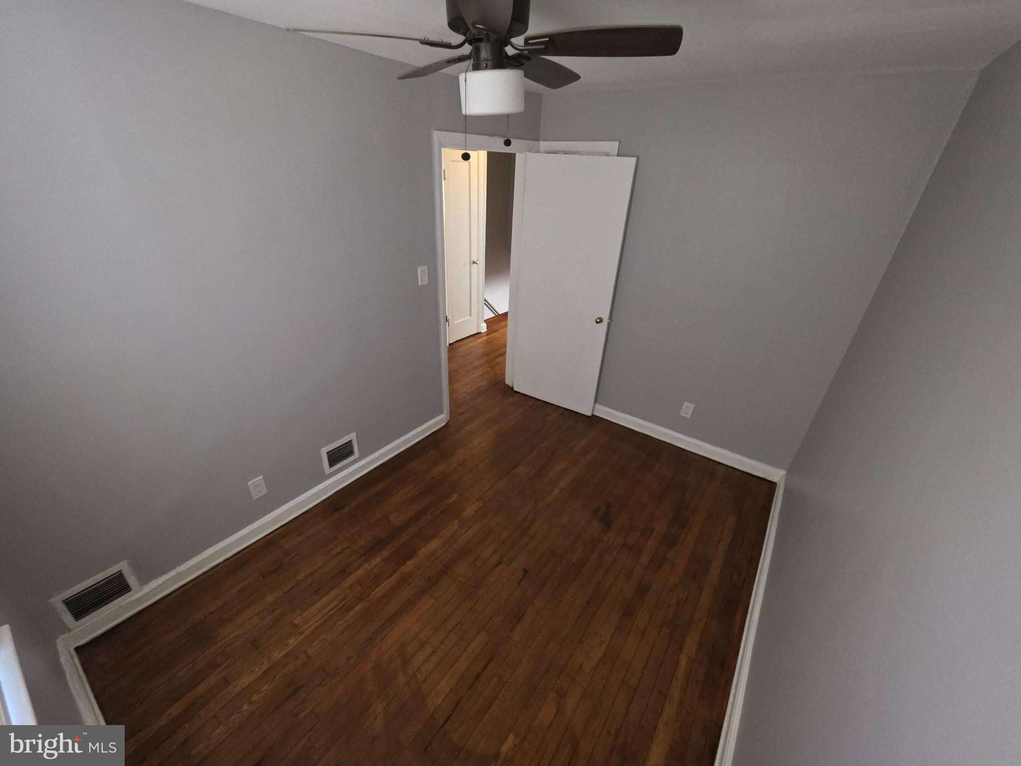 4404 Mountview Road Baltimore, MD 21229 - Photo 16 of 22 en empty room with wooden floor and ceiling fan