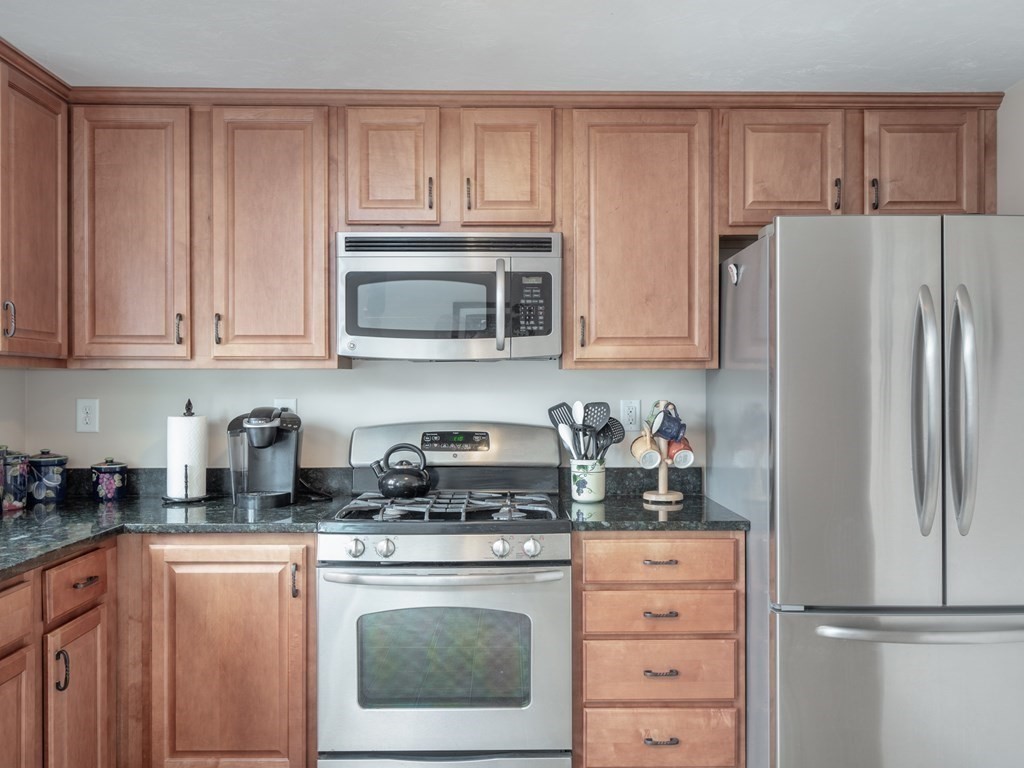 41 Boston Road, Unit 175 Billerica, MA 01862 - Photo 3 of 26 a kitchen with refrigerator a microwave stove oven and cabinets