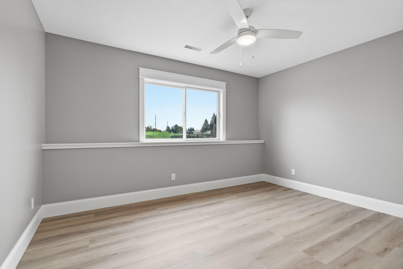 6928 Wilderness Pointe Bettendorf, IA 52722 - Photo 48 of 48 an empty room with wooden floor chandelier fan and windows