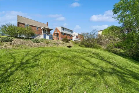 a aerial view of a house with yard and green space
