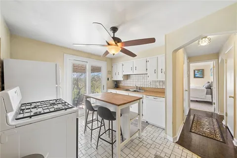 a kitchen with stainless steel appliances kitchen island a stove a refrigerator and a dining table