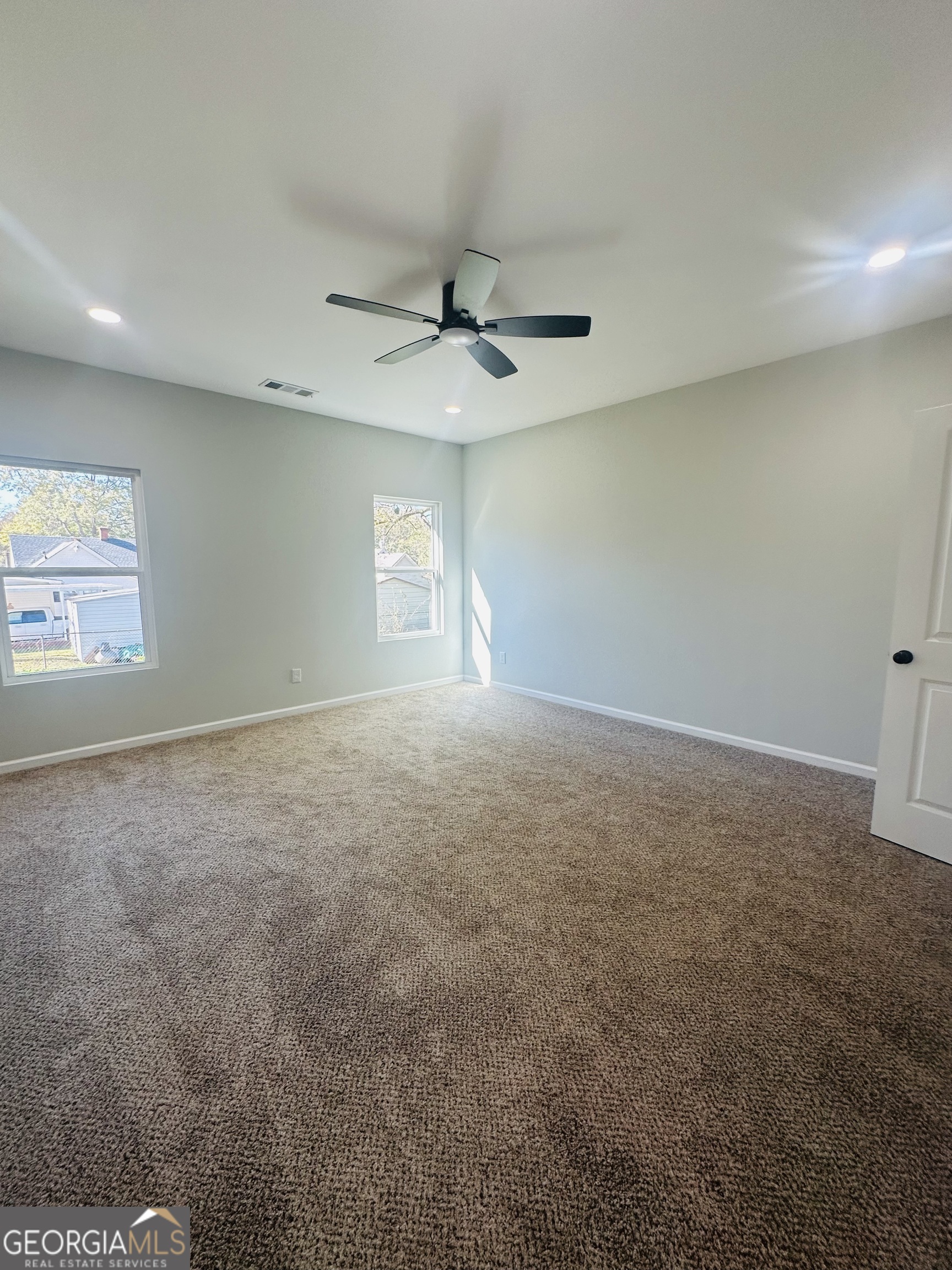 119 F Street Thomaston, GA 30286 - Photo 14 of 27 an empty room with windows and ceiling fan