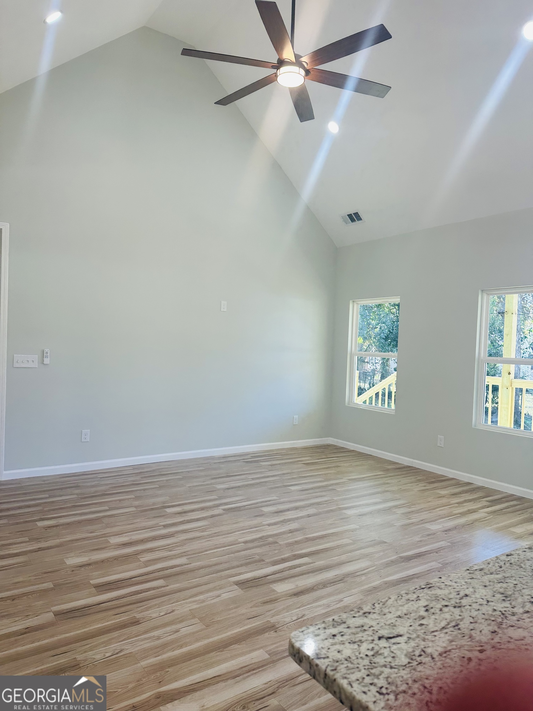 119 F Street Thomaston, GA 30286 - Photo 16 of 27 an empty room with wooden floor fan and windows
