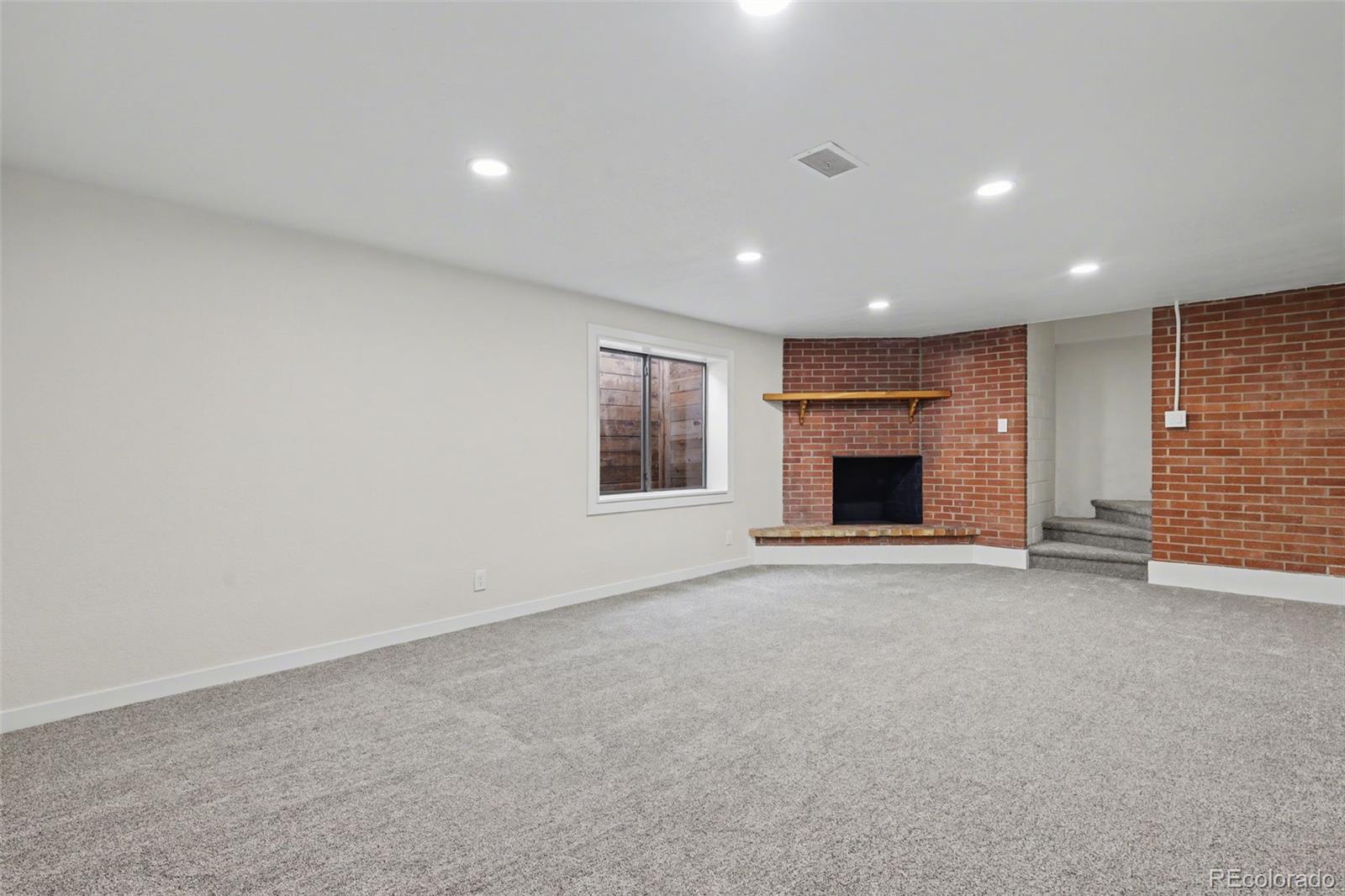 1002 Milky Way Colorado Springs, CO 80905 - Photo 24 of 39 an empty room with fireplace and window