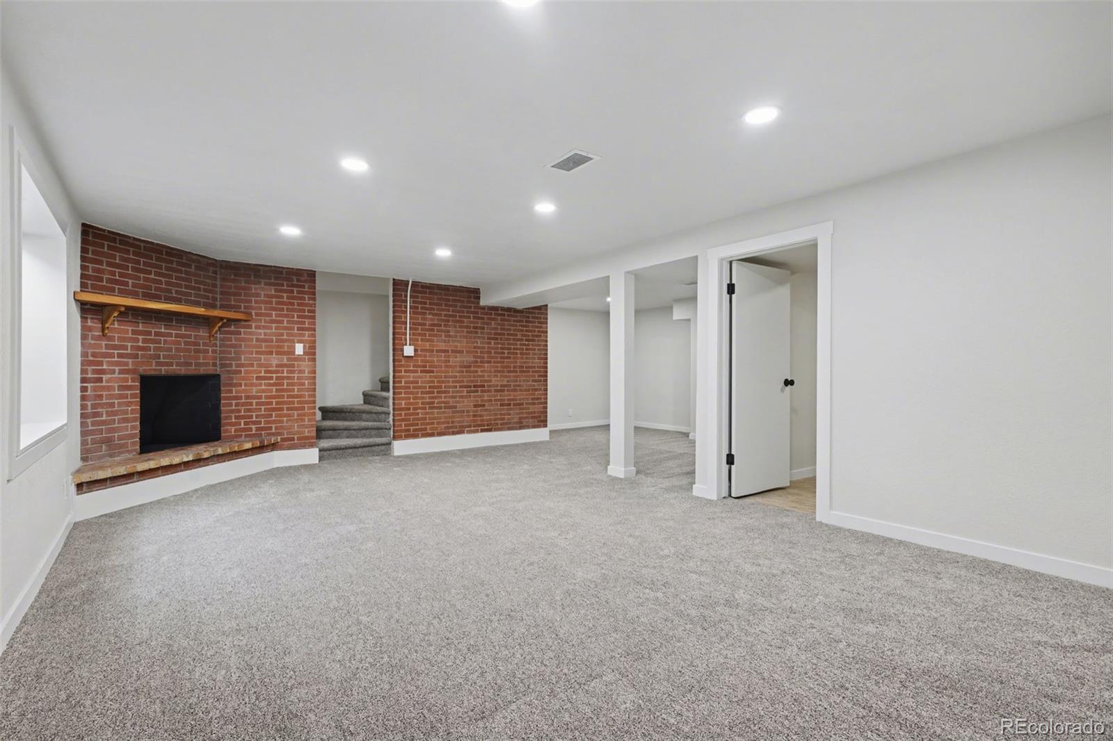 1002 Milky Way Colorado Springs, CO 80905 - Photo 25 of 39 a view of an empty room with a fireplace and a window