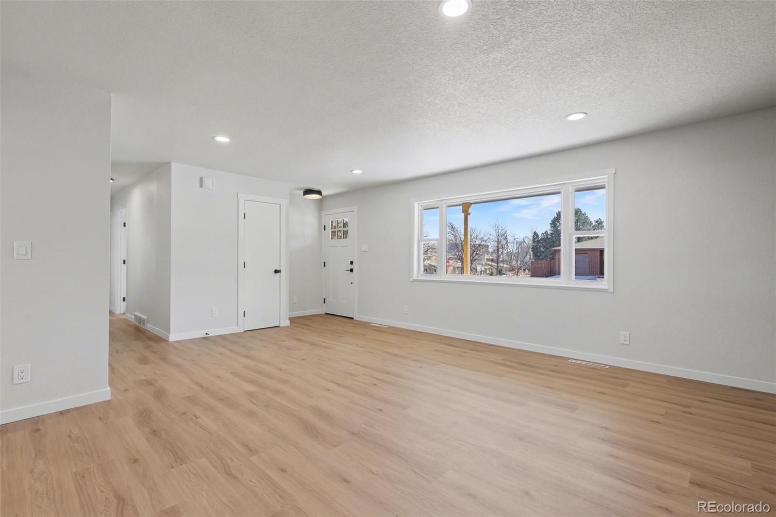 1002 Milky Way Colorado Springs, CO 80905 - Photo 3 of 39 a view of an empty room with wooden floor and window