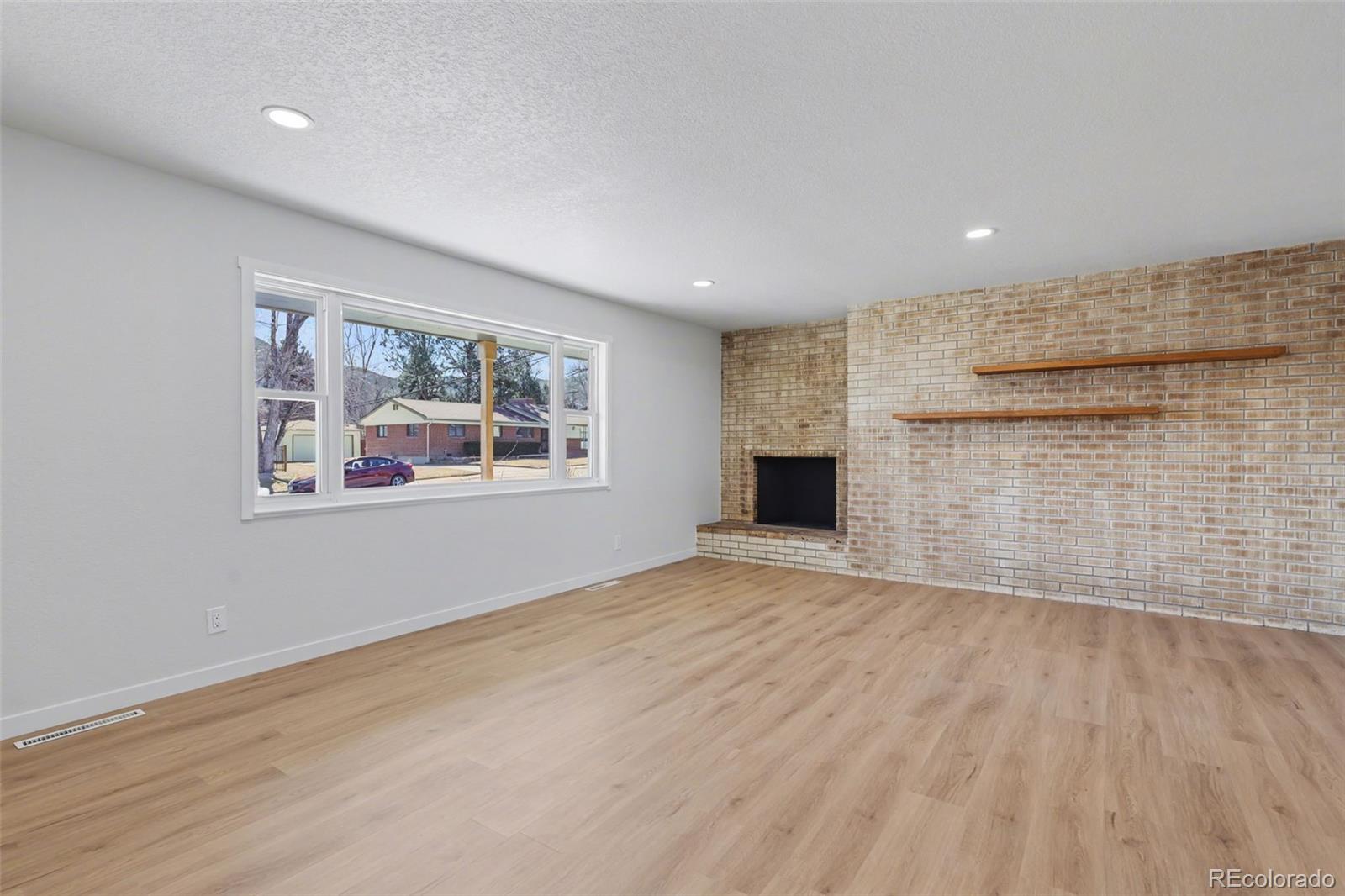 1002 Milky Way Colorado Springs, CO 80905 - Photo 5 of 39 a view of an empty room with a window and wooden floor