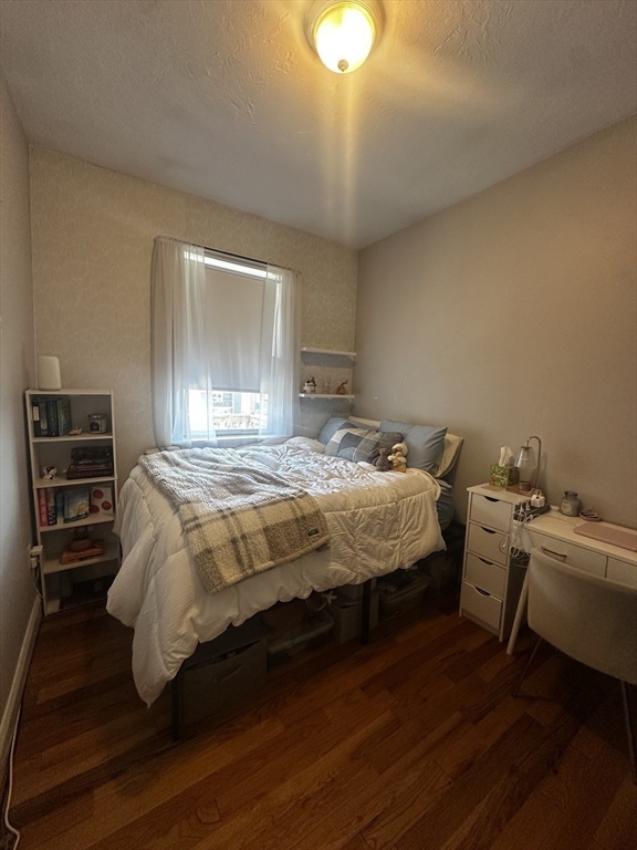 199 Athens Street, Unit 3 Boston, MA 02127 - Photo 14 of 18 a bedroom with a bed and a chandelier