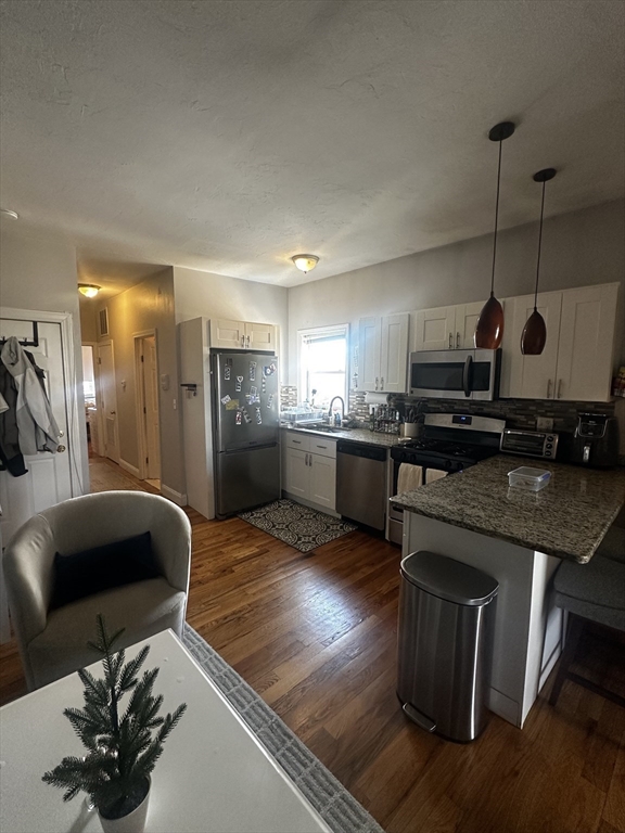 199 Athens Street, Unit 3 Boston, MA 02127 - Photo 5 of 18 a kitchen with stainless steel appliances granite countertop a sink and a stove