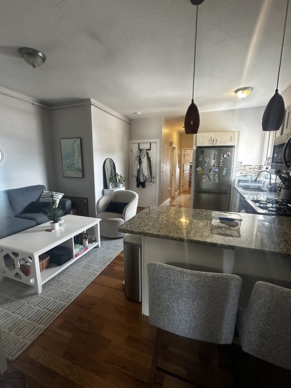 199 Athens Street, Unit 3 Boston, MA 02127 - Photo 6 of 18 a kitchen with stainless steel appliances granite countertop a stove and a wooden floors