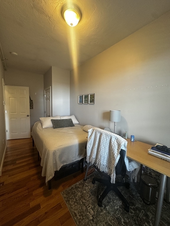 199 Athens Street, Unit 3 Boston, MA 02127 - Photo 9 of 18 a bed sitting in a bedroom next to a bathroom