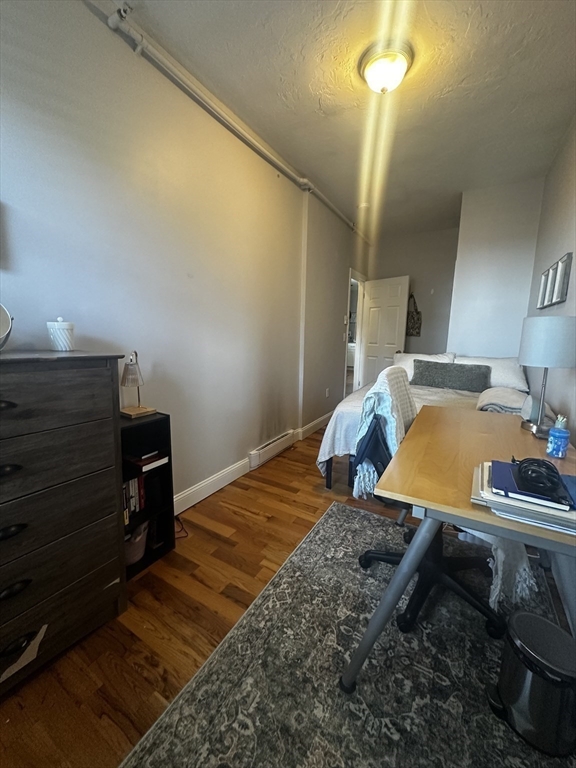 199 Athens Street, Unit 3 Boston, MA 02127 - Photo 10 of 18 a bedroom with a bed and a chandelier