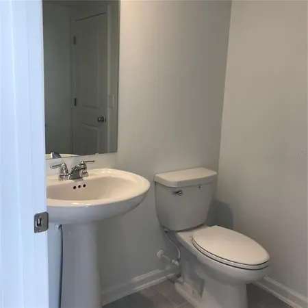 a bathroom with a sink a toilet and mirror