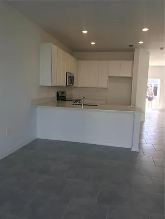 a view of a kitchen with a sink and dishwasher stove top oven with wooden floor
