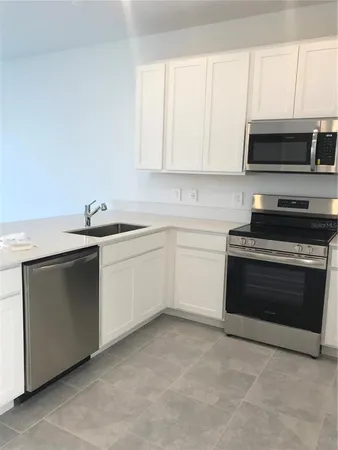 a kitchen with stainless steel appliances granite countertop a sink and a microwave