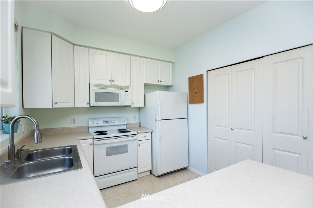 15150 140th Way Southeast, Unit G104 Renton, WA 98058 - Photo 8 of 24 a kitchen with white cabinets and white appliances