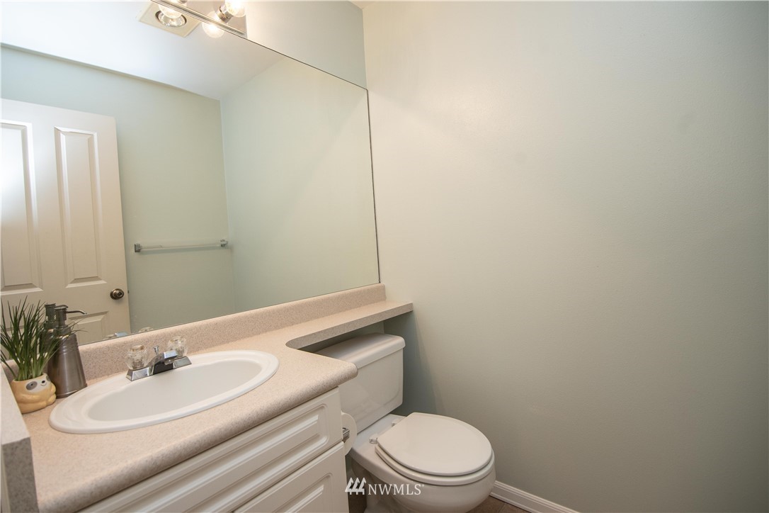 15150 140th Way Southeast, Unit G104 Renton, WA 98058 - Photo 9 of 24 a bathroom with a sink a toilet and vanity