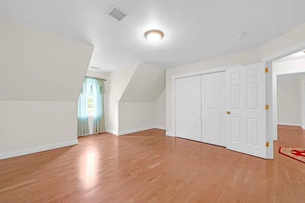 an empty room with ceiling fan and window