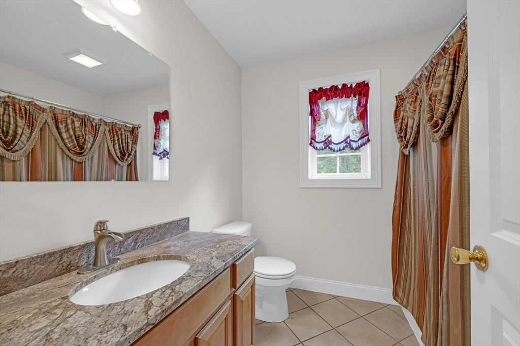 12 Malboeuf Road Ware, MA 01082 - Photo 29 of 42 a bathroom with a granite countertop sink a toilet and a mirror