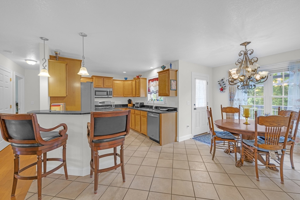 12 Malboeuf Road Ware, MA 01082 - Photo 8 of 42 a kitchen with a dining table chairs and white appliances
