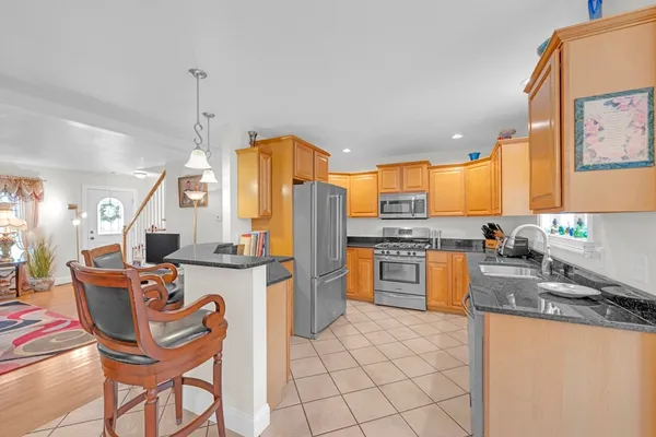 a kitchen with granite countertop a stove a sink and a microwave