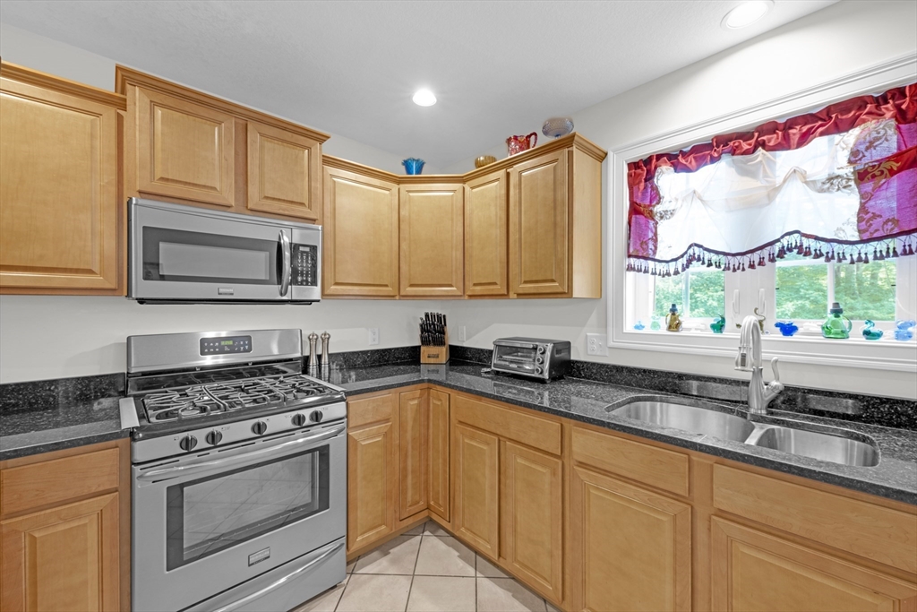 12 Malboeuf Road Ware, MA 01082 - Photo 10 of 42 a kitchen with granite countertop a stove a sink and a microwave