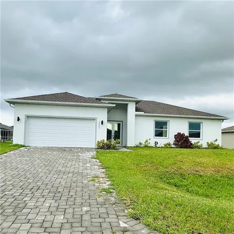 a view of a house with a yard and large parking space
