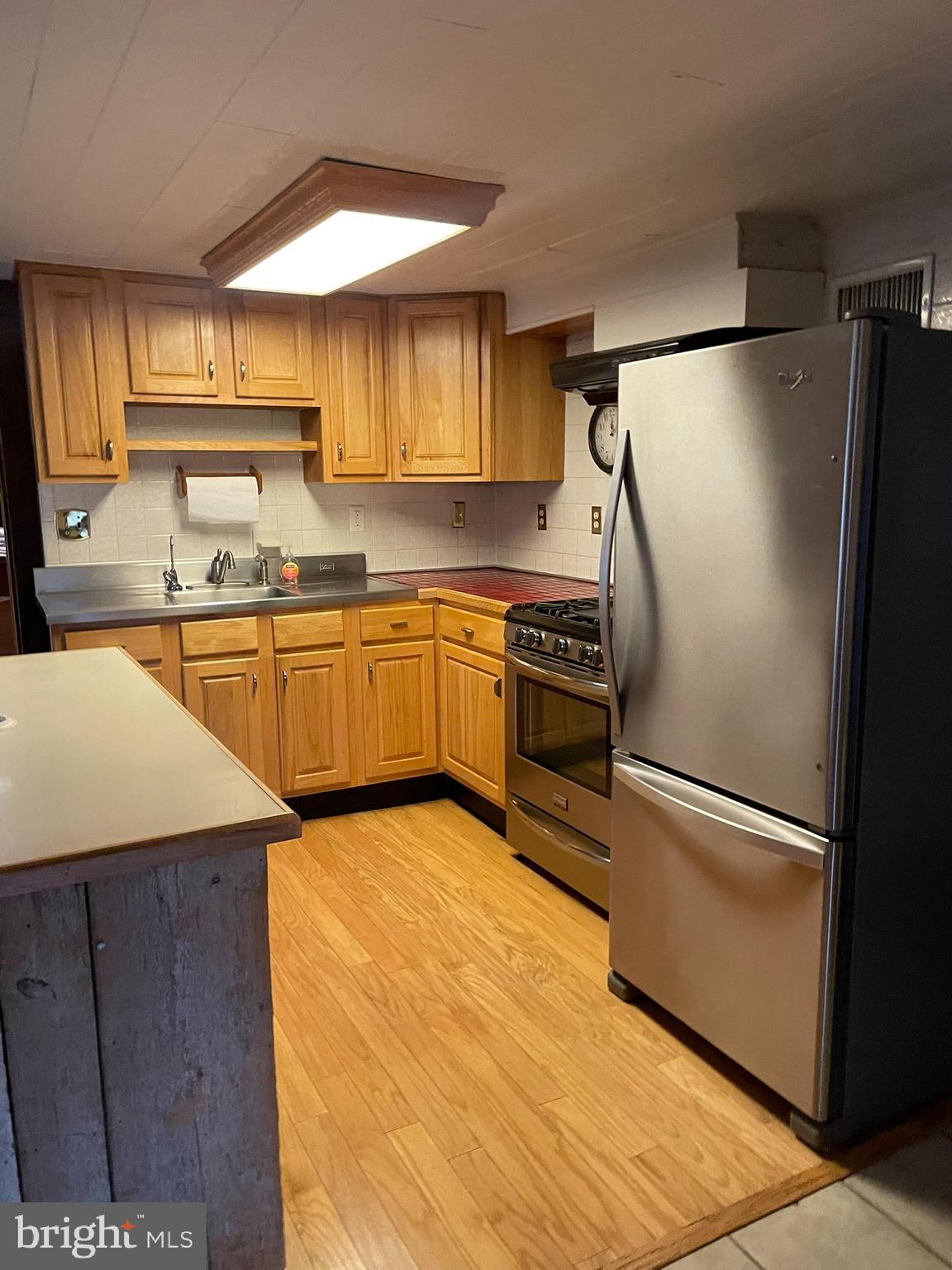 1127 Kaolin Road Avondale, PA 19311 - Photo 11 of 31 a kitchen with stainless steel appliances granite countertop a refrigerator a sink dishwasher a stove and white countertops with wooden floor