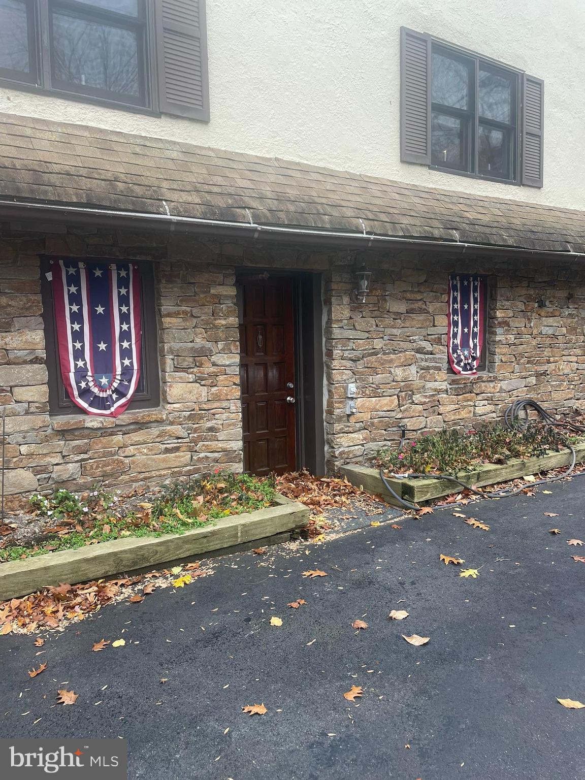 1127 Kaolin Road Avondale, PA 19311 - Photo 3 of 31 a front view of a stone house with a small yard