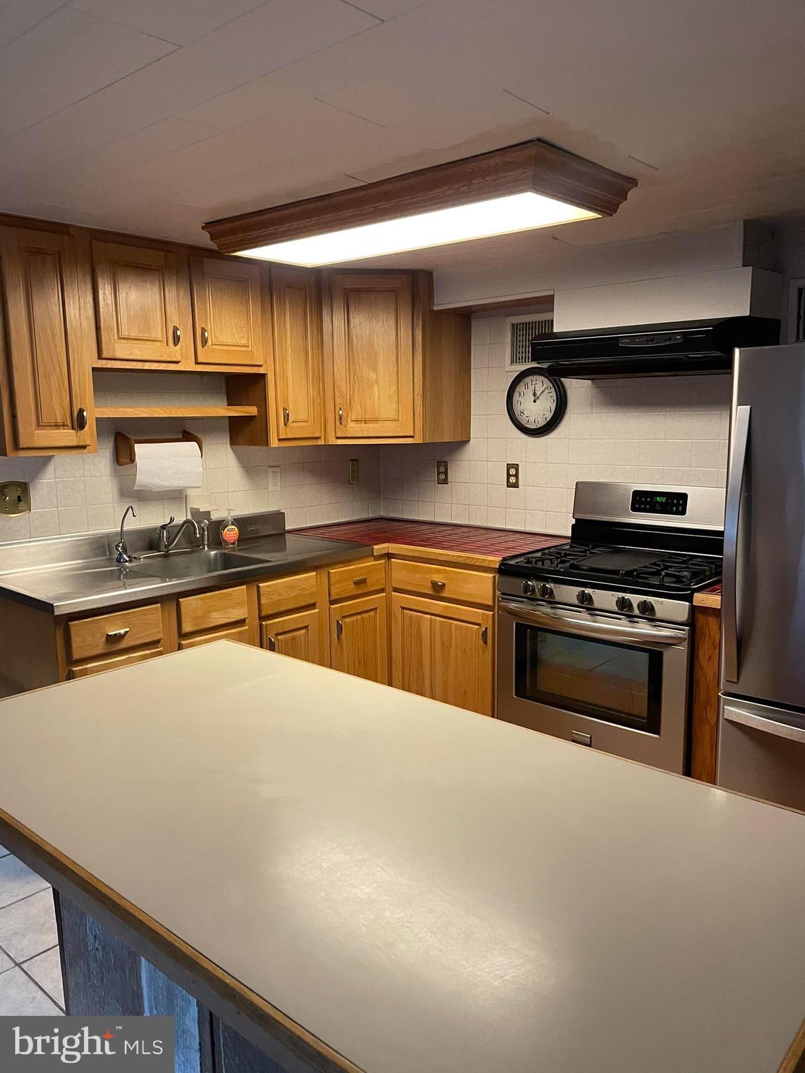 1127 Kaolin Road Avondale, PA 19311 - Photo 10 of 31 a kitchen with kitchen island a stove sink and cabinets