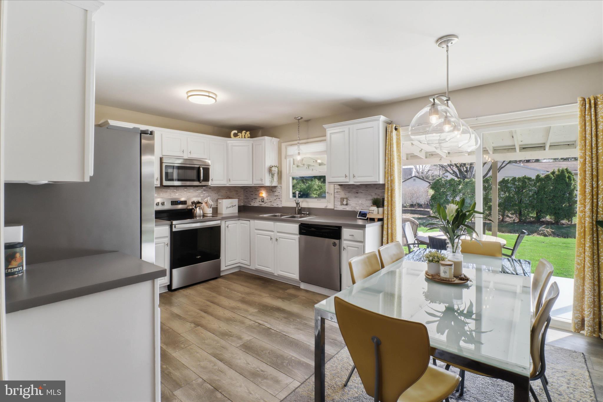 213 Skylark Road Lititz, PA 17543 - Photo 7 of 54 a open kitchen with stainless steel appliances granite countertop a stove top oven a sink dishwasher a dining table and chairs with wooden floor