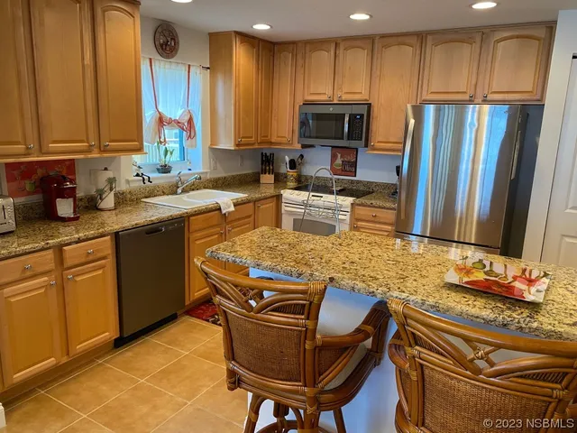 a living room with furniture a large window with kitchen view