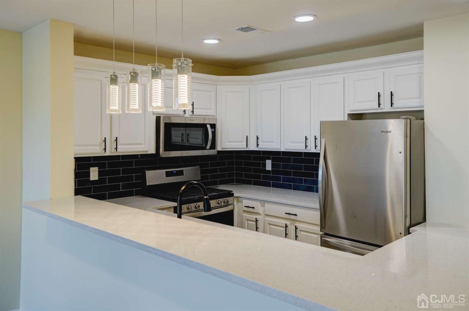 124 Edpas Road New Brunswick, NJ 08901 - Photo 11 of 24 a kitchen with stainless steel appliances a stove a microwave a sink and a refrigerator