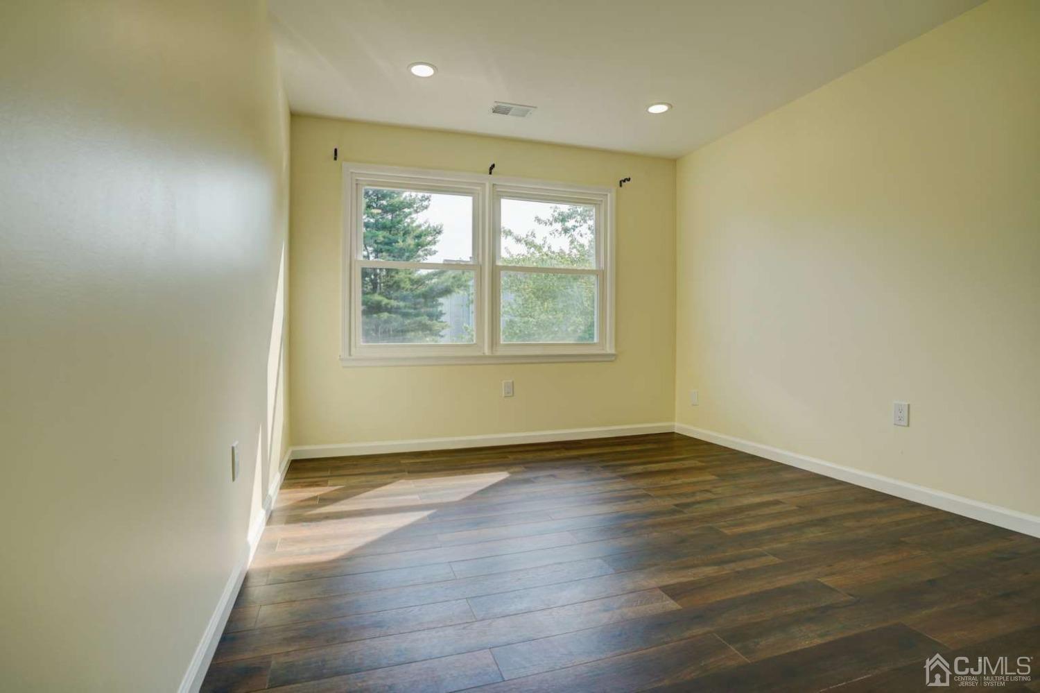 124 Edpas Road New Brunswick, NJ 08901 - Photo 20 of 24 an empty room with wooden floor and windows