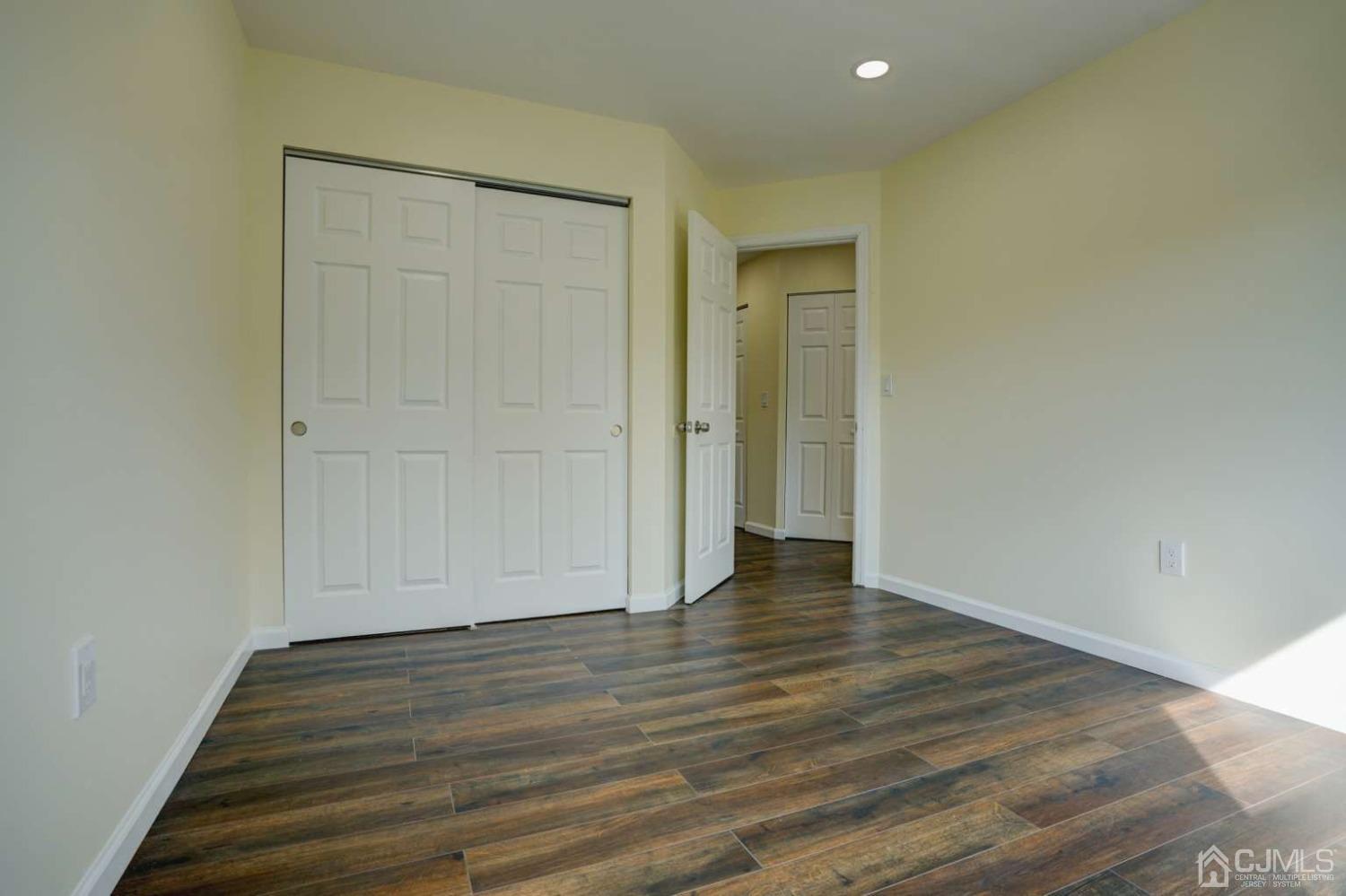 124 Edpas Road New Brunswick, NJ 08901 - Photo 21 of 24 a view of an empty room with wooden floor and closet