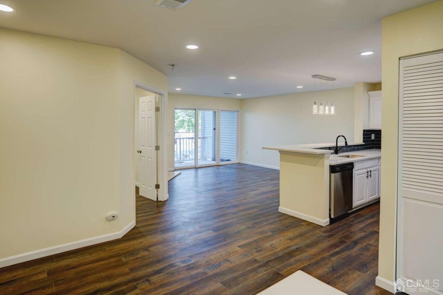 124 Edpas Road New Brunswick, NJ 08901 - Photo 7 of 24 a kitchen with stainless steel appliances kitchen island wooden floors and view living room