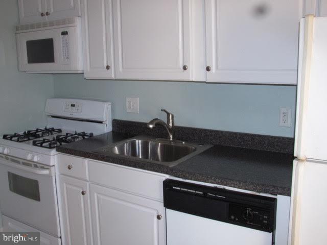 7 Hamill Road, Unit 7B Baltimore, MD 21210 - Photo 6 of 14 a kitchen with granite countertop white cabinets and a stove