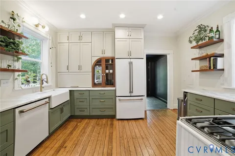 a kitchen with kitchen island white cabinets and stainless steel appliances