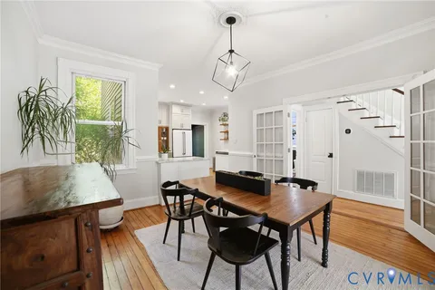a kitchen with stainless steel appliances a dining table chairs stove and refrigerator