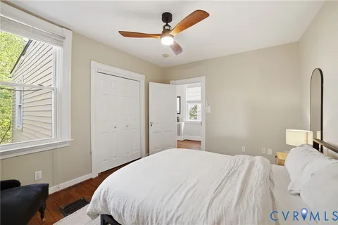 a bedroom with a bed a fireplace and a large window