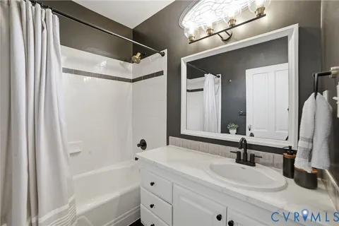 a bathroom with a double vanity sink mirror and bathtub