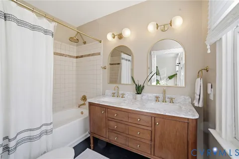 a bathroom with a granite countertop sink a mirror and shower