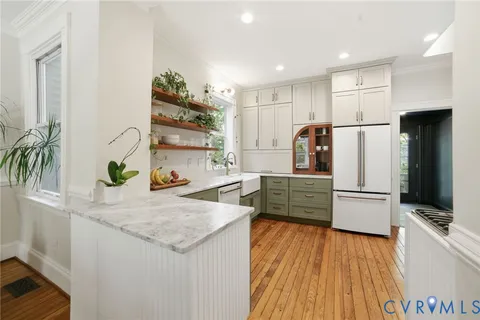 a kitchen with stainless steel appliances granite countertop a refrigerator and a stove top oven