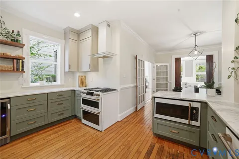 a kitchen with stainless steel appliances kitchen island granite countertop a stove a sink and a refrigerator