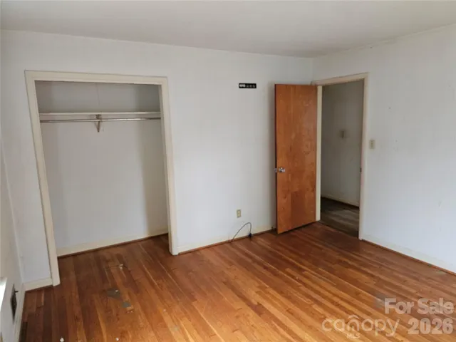 a view of a livingroom with wooden floor and a bathroom
