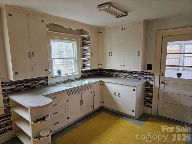 a bathroom with a granite countertop sink and mirror with bathtub