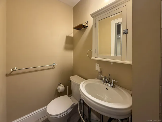 a bathroom with a sink a toilet and mirror