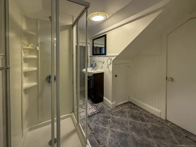 a bathroom with a glass shower door and a sink