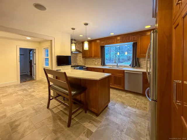 a kitchen with a table chairs sink and refrigerator